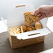 A hand holding a piece of fried chicken in a Barn Take Out Lunch Box with Fresh print.