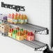 A Regency black wire wall mount shelf with beverages on it.