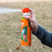 A person holding a can of SC Johnson OFF! Outdoor Fogger spraying it.