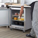 A man putting food into a Beverage-Air undercounter refrigerator in a kitchen.