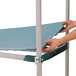 A person placing a blue removable mat on a MetroMax i shelf.