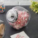 A Choice glass jar full of peppermint candy with a chrome lid.