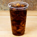 A Fabri-Kal Greenware plastic cup filled with brown liquid and ice.