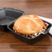 A sandwich in a small black foam container.