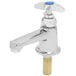 A silver faucet with a blue knob.