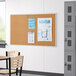 A Quartet cork board with papers on it in a classroom.