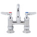 A T&S chrome deck-mounted faucet with two lever handles and red labels.