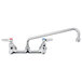 A T&S chrome wall mount faucet with lever handles and a swing spout.