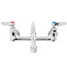A T&S chrome wall mount faucet with 2 lever handles.