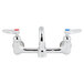 A T&S chrome wall mount faucet with two lever handles and two faucets.