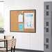 A classroom with a Quartet cork board with papers pinned on the wall.