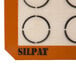 A white Sasa Demarle SILPAT® baking mat with black circles.