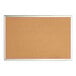 A Quartet cork board with a silver frame.