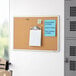 A Quartet cork board with a silver aluminum frame.