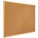 A Quartet cork board with a wooden frame.