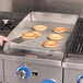 a person cooking pancakes on a fryer