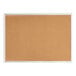 A Quartet cork board with a silver frame.