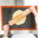 A person rolling dough on a Sasa Demarle silicone baking mat.