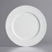 A close-up of a Tabletop Classics by Walco white plastic charger plate.