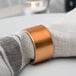 A Tabletop Classics by Walco copper napkin ring on a white napkin.