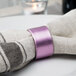 A purple napkin with a Tabletop Classics by Walco purple polypropylene napkin ring on it.