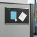 A black Quartet bulletin board with papers and notes on it.