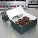 A 10" x 8" x 4" brown bakery box with a chocolate muffin inside.