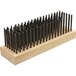 A Texas Grill Brush with a wooden handle and black metal bristles.