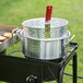 A Backyard Pro aluminum fry pot with a basket on a grill.