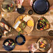 A table with Homer Laughlin Indigo™ china plates and glasses of food on it.
