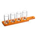 An Acopa wooden flight paddle with four straight up tasting glasses on it.