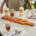 An Acopa flight paddle with desserts in glasses and spoons on a table.