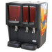 A black Crathco refrigerated beverage dispenser with red and clear drinks.