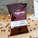 A case of Ellis Mezzaroma Royal Sumatra coffee packets on a table.