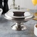 A Town stainless steel serving bowl with a lid on a table.