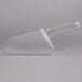 A clear plastic scoop on a white surface.