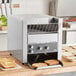 A Vollrath conveyor toaster with toasted bread on a counter.