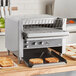 A Vollrath conveyor toaster on a kitchen counter with toast.