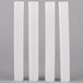 Three white plastic Wilton cake pillars.