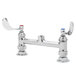 A white B-0220-LN-WH4 deck mounted faucet base with two swivel outlets and wrist handles.