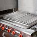 A 24" x 27" x 4" Add-On 4 Burner Charbroiler on a stove with metal grates.