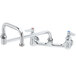 A T&S chrome wall mounted faucet with double-jointed swing spout and lever handles.