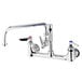 A chrome T&S wall mount pantry faucet with two swing nozzles and two lever handles.