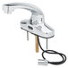 A T&S chrome faucet with a sensor and supply lines.