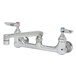 A T&S chrome wall mount faucet with lever handles and two faucets.