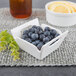 a bowl of blueberries on a place mat