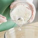 A person pouring white powder into a bowl.