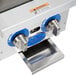 A Globe countertop gas hot plate on a counter with two knobs.