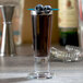 A Libbey cordial glass filled with a blue drink and blueberries.