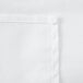 A close up of a white rectangular fabric with a hemmed edge.